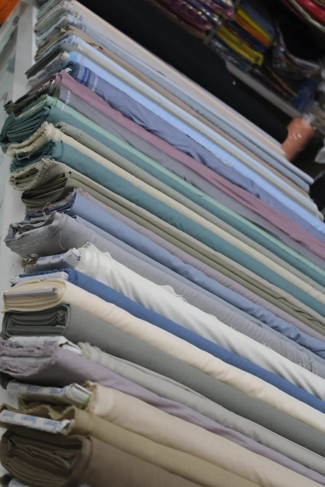 Premium kurta-pajama fabric rolls in soft neutral and pastel shades