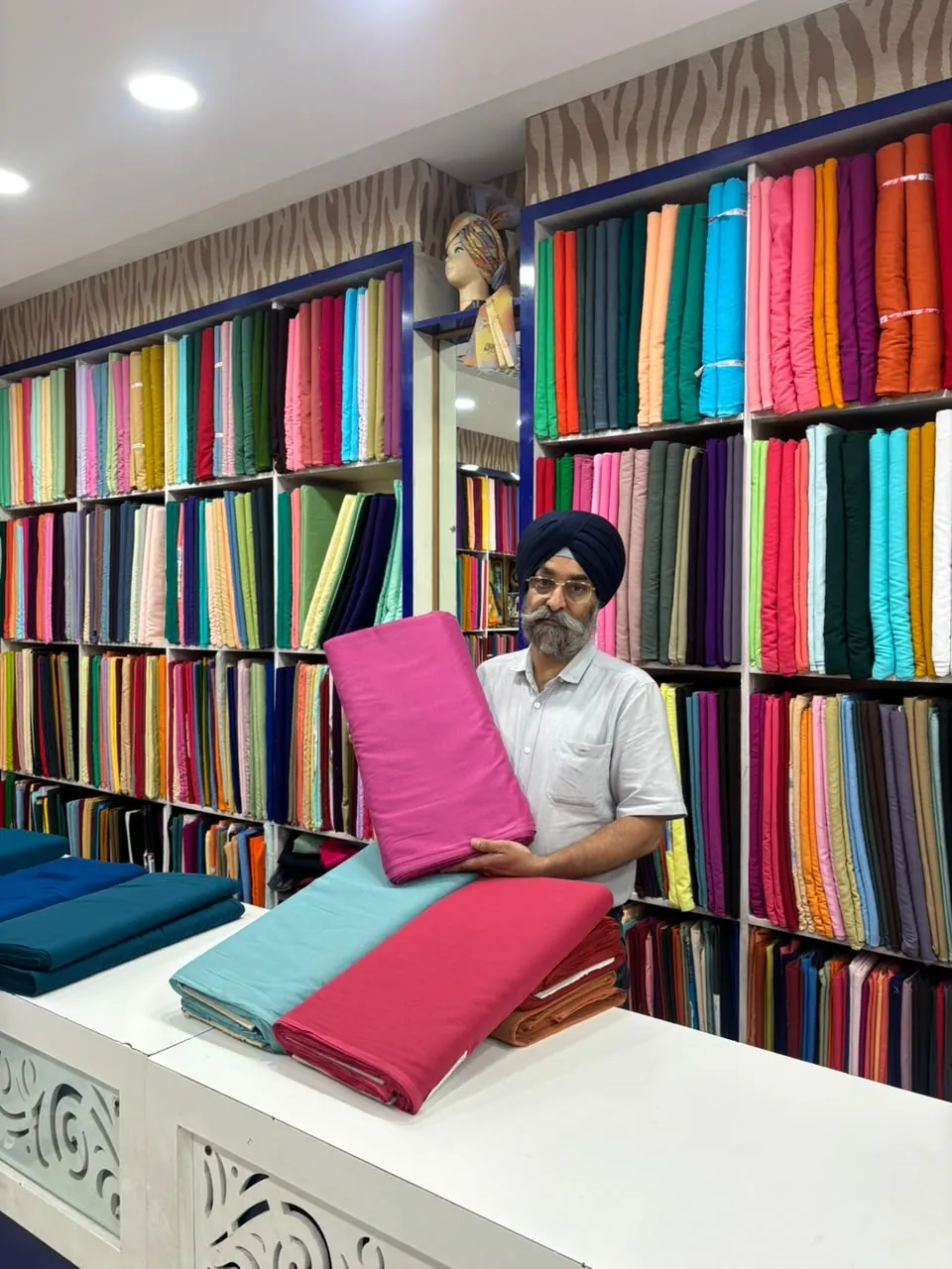 Owner presenting premium fabrics inside Sahney Pagri House