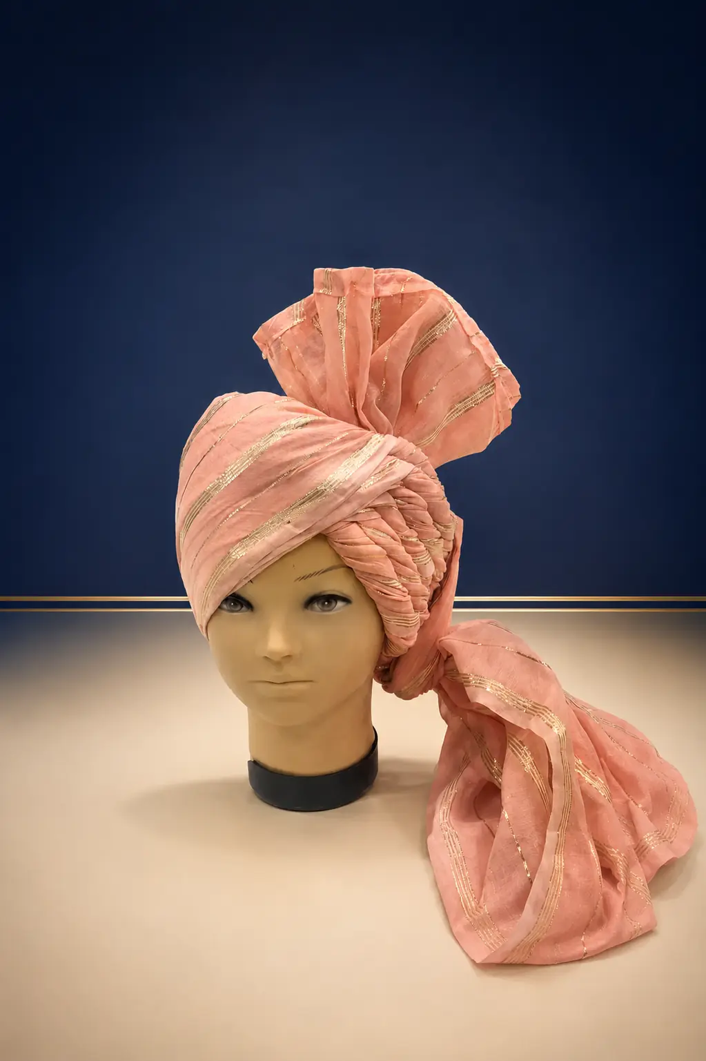 Complete peach Rajasthani safa with gold detailing on a mannequin